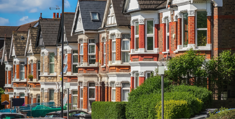 A row of terraced, red-brick Victorian houses in London
